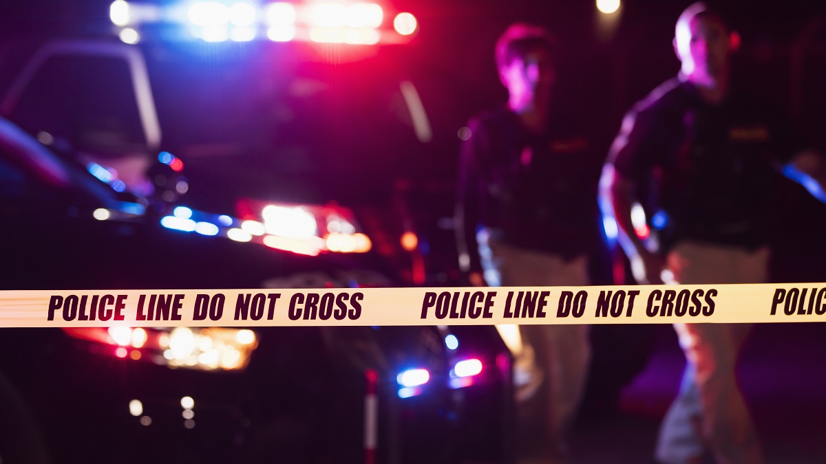 Two police officers behind crime scene tape