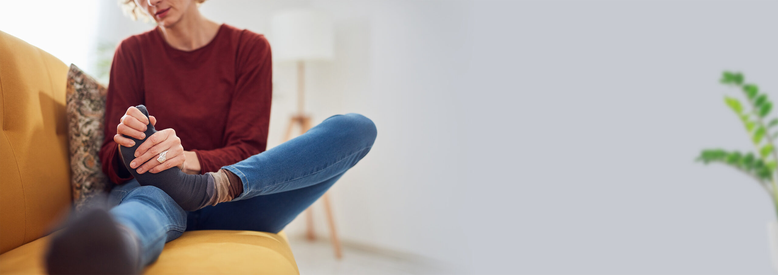 Woman,With,Feet,Intense,Pain,Sitting,On,A,Couch,At